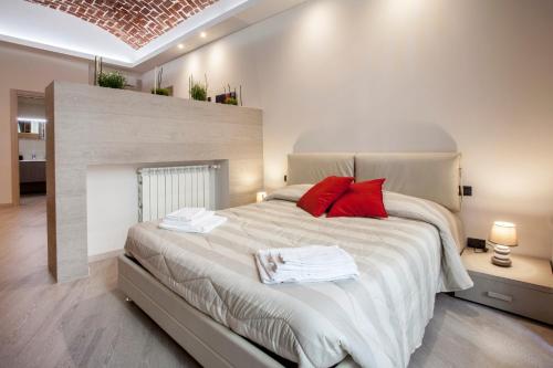 um quarto com uma cama grande e almofadas vermelhas em Torino Suite em Turim