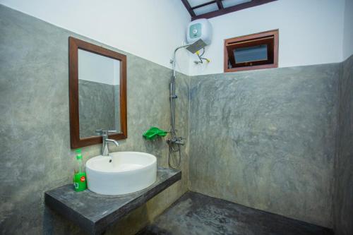a bathroom with a sink and a mirror at Noha Villa in Talpe