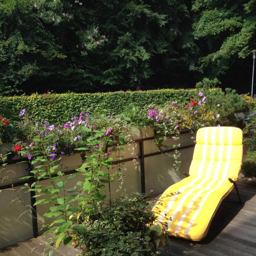 a yellow bench in a garden with flowers at Ferienwohnung Seepferdchen in Timmendorfer Strand