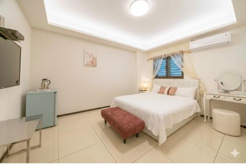 a white bedroom with a bed and a window at 窩心の家民宿 in Suao