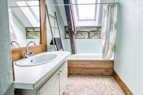 a bathroom with a sink and a shower and a tub at Les gîtes du Gauliat in Espartignac