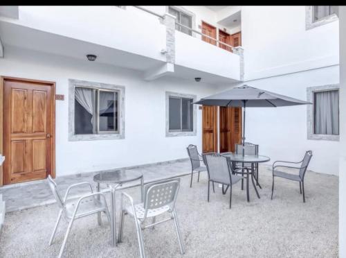 a patio with a table and chairs and an umbrella at Hotel Yukon in Playa del Carmen