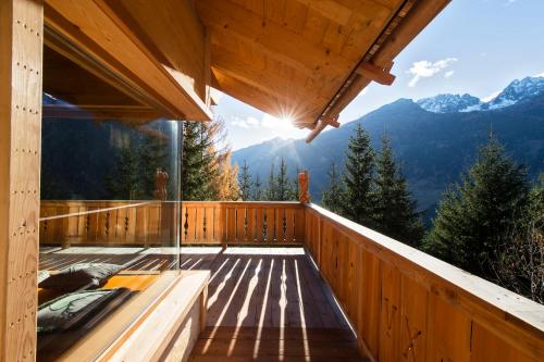 a wooden deck with a view of the mountains at Wuidererhüttn, Charlet in Alleinlage mit freistehendem Saunahaus in Großkirchheim