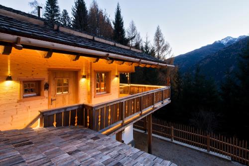 a wooden house with a deck in the mountains at Wuidererhüttn, Charlet in Alleinlage mit freistehendem Saunahaus in Großkirchheim
