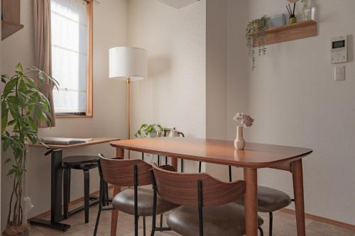 a dining room with a wooden table and chairs at SHIKA HOME Yokohama Chinatown-Luxury長期滞在OK-Family Groupに最適-キッチン完備 落ち着きある空間 in Yokohama