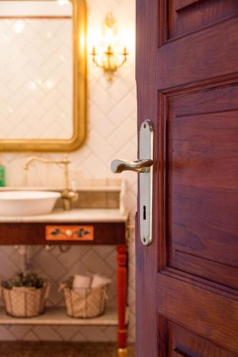 a bathroom door with a sink and a mirror at Aminta Home in Las Palmas de Gran Canaria