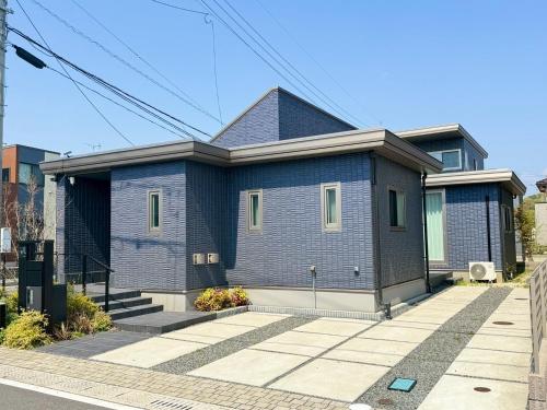 a blue brick house on the side of a street at Akikawa Koshi 8 プレミアム鉄骨 一棟貸切ヴィラ in Yuge
