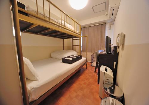 a bedroom with two bunk beds and a television at Dormy Inn EXPRESS Asakusa in Tokyo
