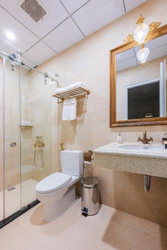 a bathroom with a toilet and a shower and a sink at Mallorie Hotel Dalat in Xuan An