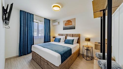 a bedroom with a bed and a window with blue curtains at Villa Antea by Villas Guide in Vela Luka