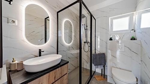 a bathroom with a sink and a toilet and a mirror at Villa Antea by Villas Guide in Vela Luka