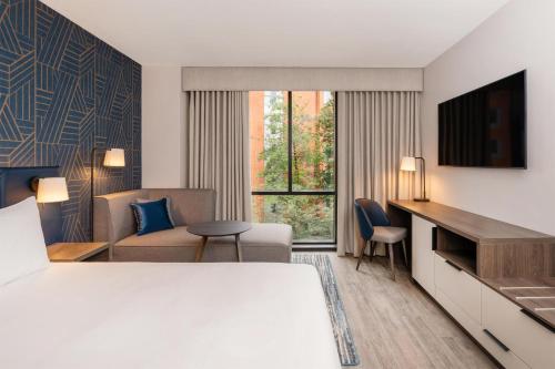 a hotel room with a bed and a living room at Hyatt Place Leeds in Leeds