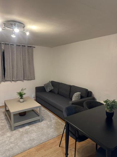 a living room with a couch and a table at Maya-Ama Cosy 2 Bedroom Flat Near Lakeside Shopping Centre And Grays in West Thurrock