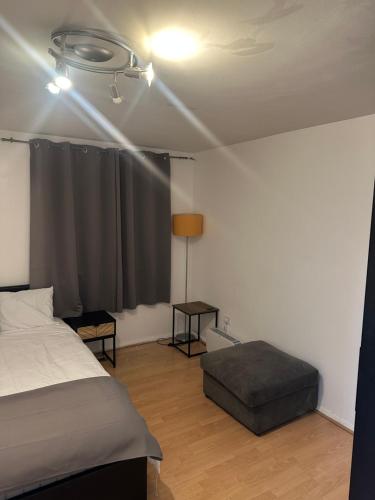 a bedroom with a bed and a table and a window at Maya-Ama Cosy 2 Bedroom Flat Near Lakeside Shopping Centre And Grays in West Thurrock