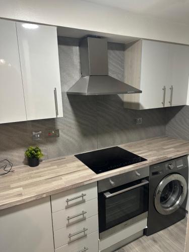 a kitchen with a stove and a stove top oven at Maya-Ama Cosy 2 Bedroom Flat Near Lakeside Shopping Centre And Grays in West Thurrock