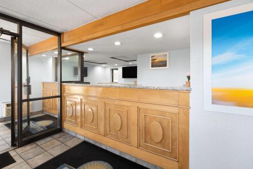 a room with a large counter with a television at Days Inn by Wyndham Charlotte University in Charlotte