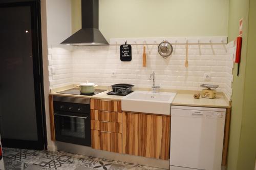 uma cozinha com um lavatório e um fogão em T2P Félix House em Vila Nova de Gaia