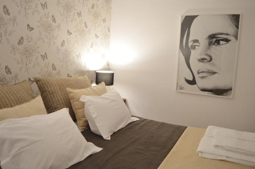 Un dormitorio con una cama y una foto de una mujer en T2P Félix House, en Vila Nova de Gaia