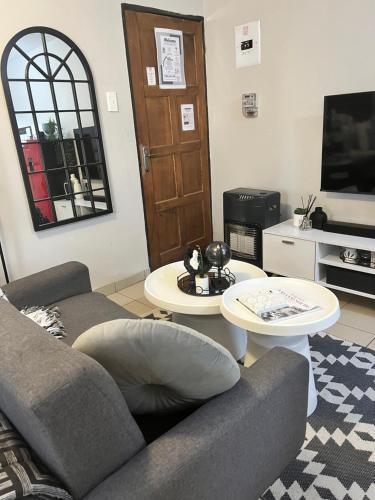 a living room with a couch and two tables at B-Hive at Devland Room 3 in Soweto