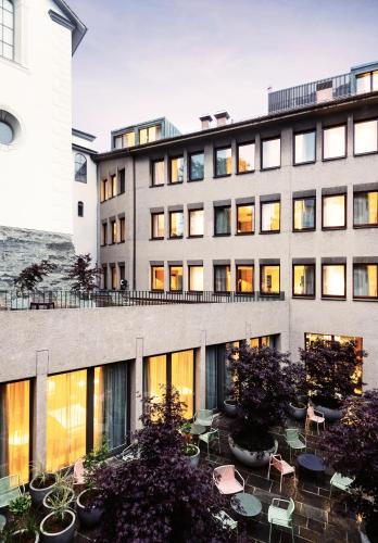 a building with tables and chairs in a courtyard at Sorell Boutique-Hotel St Peter Zürich in Zurich