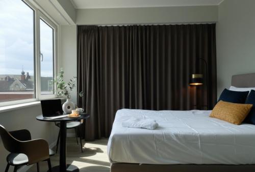 a bedroom with a bed and a desk with a laptop at Comfortable Room in Raamsdonksveer, Free Parking in Raamsdonksveer