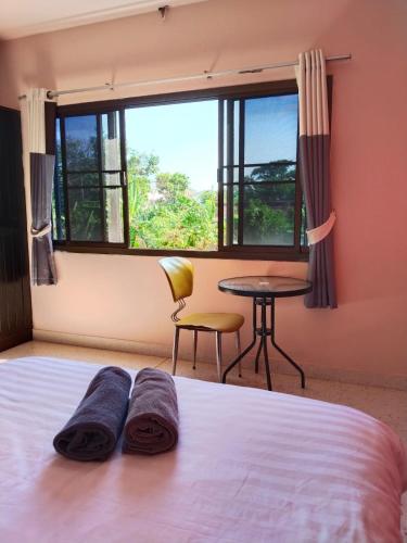 a bedroom with a bed and a table and a window at Krabi Hotel Agency in Krabi