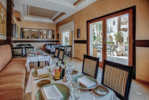 a dining room with a table and chairs and a couch at JAZ Makadi Star & Spa - Adults Only in Hurghada