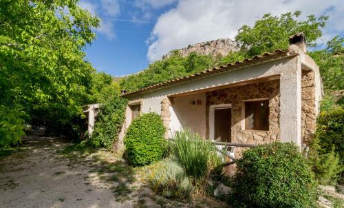 a small stone house with a mountain in the background at Casas Rurales Los Enebros Nerpio in Nerpio