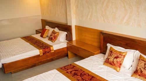 two beds in a hotel room with two at Khách Sạn Ngọc Châu in Lấp Vò