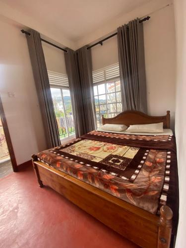 a bedroom with a bed with a large window at Budget Comfort Villas in Boragasketiya