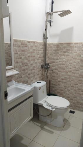a bathroom with a toilet and a sink and a tub at Jessa's Transient Studio with Balcony in Masbate