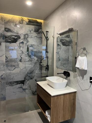 a bathroom with a sink and a shower at Konwar Inn & Suites in Golāghāt
