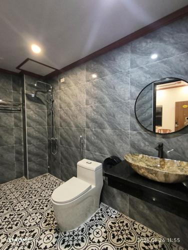 a bathroom with a toilet and a sink and a mirror at Tam Coc Cozy Hotel in Vũ Lâm