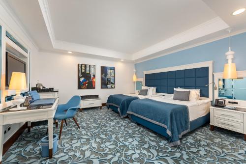 a hotel room with two beds and a desk at Azure Villas By Cornelia in Belek