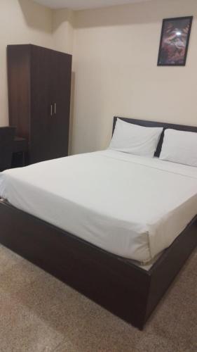 a bedroom with a large bed with white sheets and pillows at AB Residency in Chennai