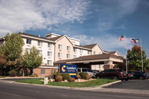 a hotel with a car dealership in front of a building at Comfort Suites Salt Lake City Airport in Salt Lake City
