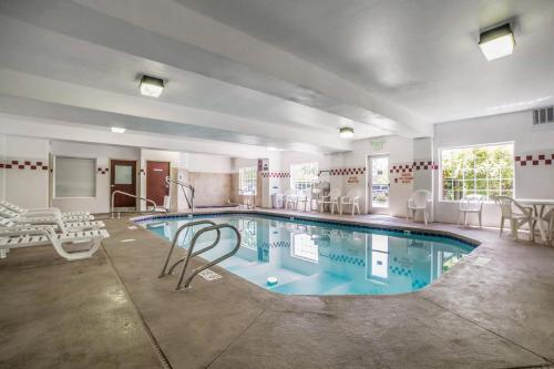 a pool in a hotel room with chairs around it at Comfort Suites Salt Lake City Airport in Salt Lake City