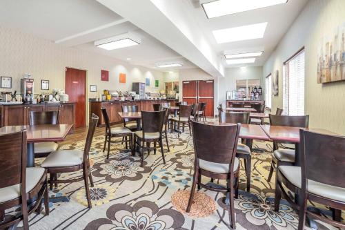 a restaurant with tables and chairs and a bar at Comfort Suites Salt Lake City Airport in Salt Lake City