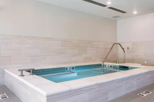 a large bath tub in a white room with at Comfort Inn & Suites Salt Lake City Airport in Salt Lake City