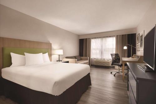 a hotel room with a large bed and a desk at Country Inn & Suites by Radisson, Waterloo, IA in Waterloo