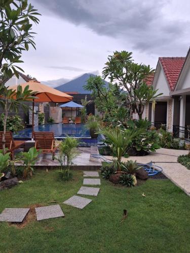 a backyard with a swimming pool and a house at GHangga Amed in Karangasem