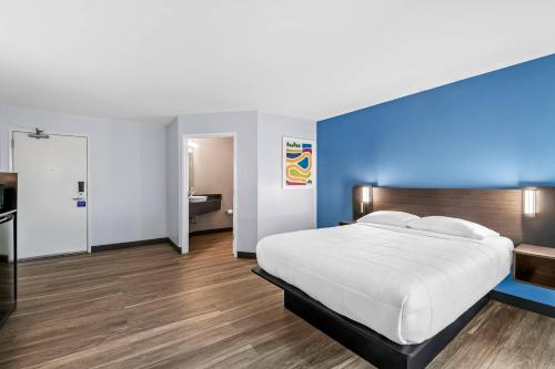 a bedroom with a white bed and a blue wall at Park Inn by Radisson, Grand Island I-80 in Grand Island