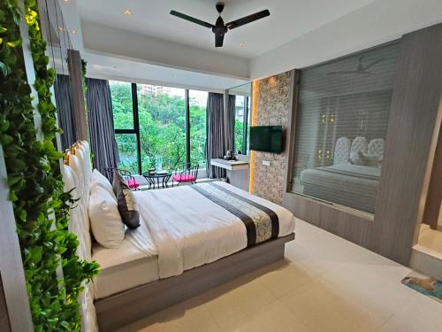a bedroom with a large bed and a large window at Hotel Melody Boutique Thane in Thane