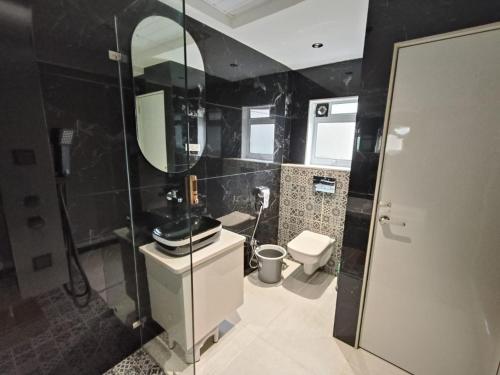 a bathroom with a toilet and a sink and a mirror at Hotel Melody Boutique Thane in Thane