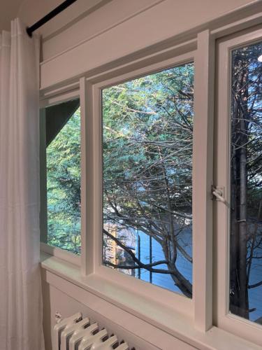 a window with a view of a tree at Modern Queen Room Ensuite Bathroom Vancouver West in Vancouver