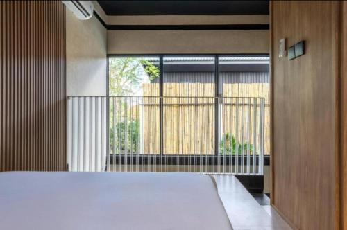 a bedroom with a large bed and a large window at NOMAD Chic Private Pool Loft in Canggu, all inclusive stay in Dalung