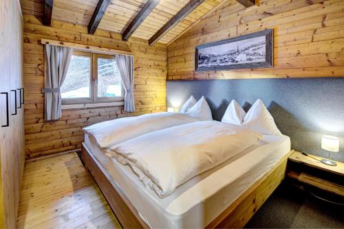 a bedroom with a bed in a wooden cabin at Ferienhaus Gasteg in Maria Alm am Steinernen Meer