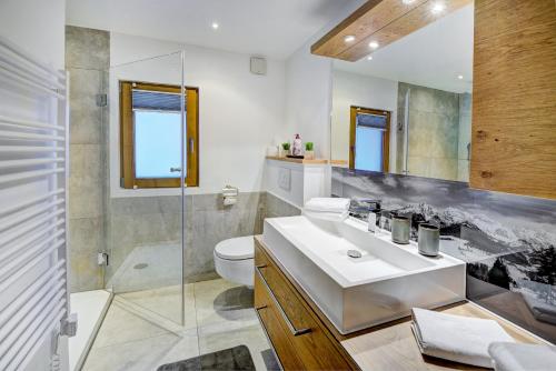 a bathroom with a sink and a toilet and a shower at Ferienhaus Gasteg in Maria Alm am Steinernen Meer