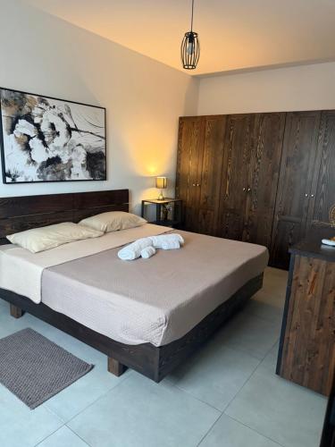 a bedroom with a large bed with wooden cabinets at 5B Luxury Apartment in Tas-Samra
