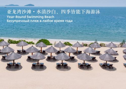 a group of umbrellas and chairs on the beach at The St. Regis Sanya Yalong Bay Resort in Sanya